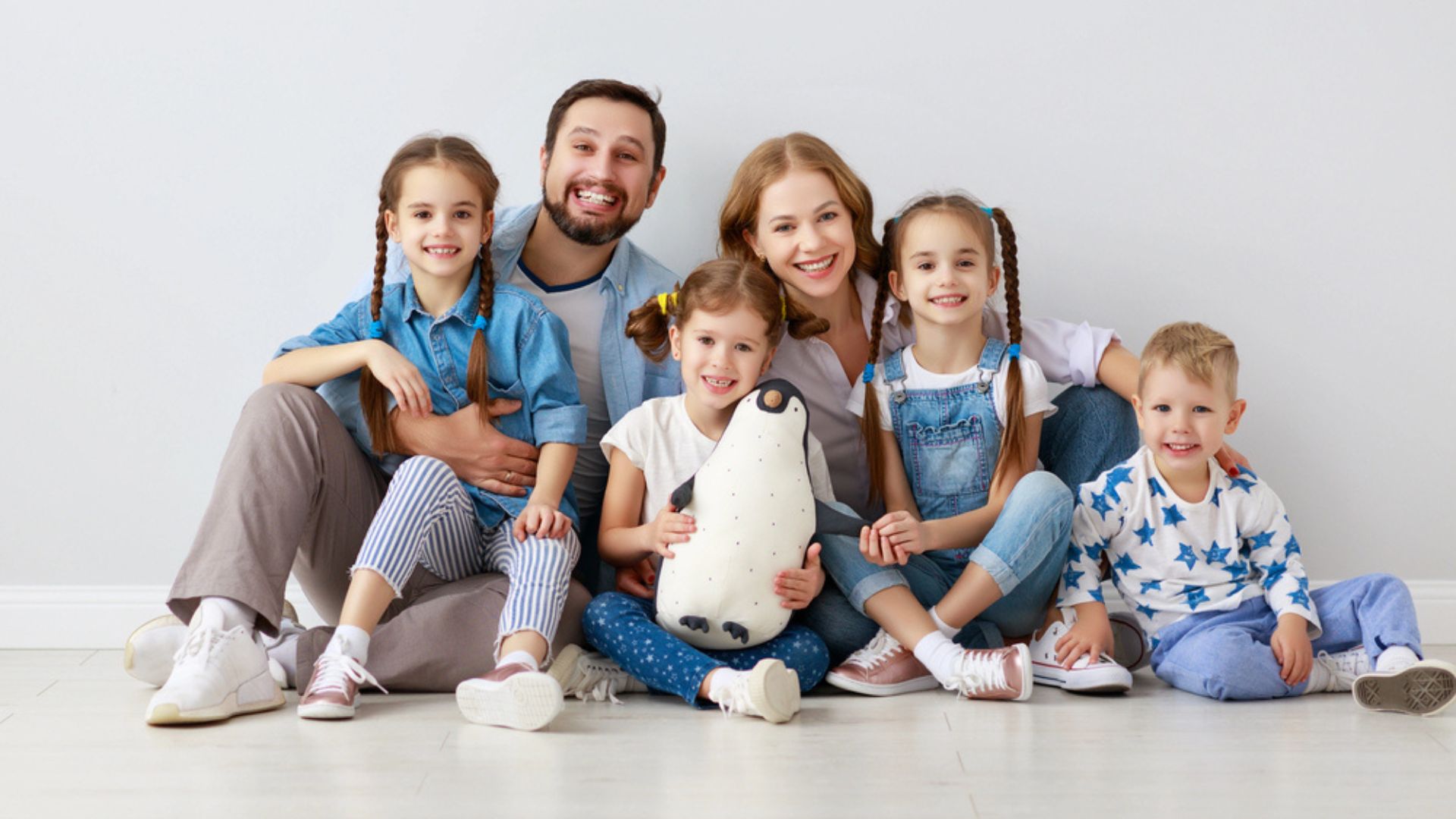 Une famille nombreuse souriante posant ensemble, symbolisant les avantages de l'aide ménagère à domicile pour alléger la gestion quotidienne.